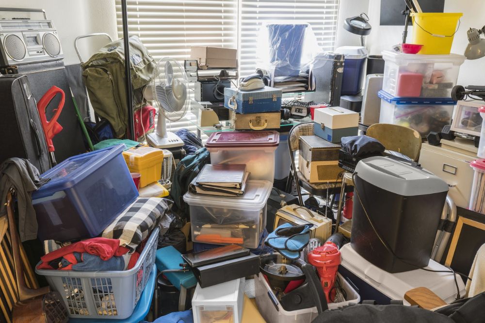 A chaotic room filled with numerous belongings, showcasing the necessity for a clean-out service in Seattle, WA.