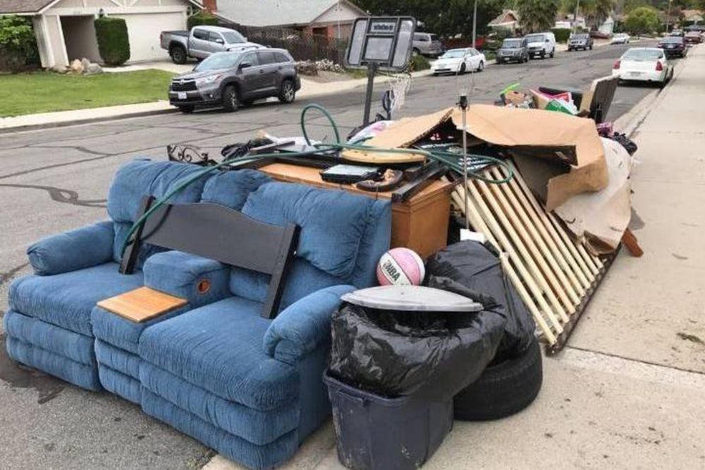 A couch and assorted furniture are abandoned on the street, highlighting an indoor junk removal service in Seattle, WA.