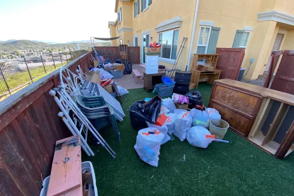 A disorganized backyard filled with various trash items and furniture, showcasing the need for junk removal in Seattle, WA.