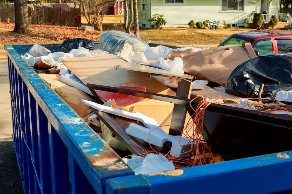 A dumpster overflowing with furniture and assorted items, highlighting a specialized junk removal service in Seattle, WA.